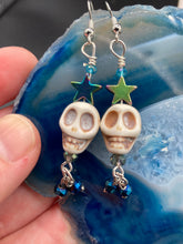Load image into Gallery viewer, Mini Howlite Skull Bead Earrings, Stardust Galaxy Cosmos large star shaped rainbow hematite beads and light blue glass bead for a pastel goth vibe. Two small dark blue glass beads on the bottom to add some movement. Perfect for a witch, goth, or day of the dead outfit. You can dress these up or down, it will definitely give your outfit a unique look.   Measurements: 2 ” in length
