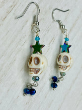 Load image into Gallery viewer, Mini Howlite Skull Bead Earrings, Stardust Galaxy Cosmos large star shaped rainbow hematite beads and light blue glass bead for a pastel goth vibe. Two small dark blue glass beads on the bottom to add some movement. Perfect for a witch, goth, or day of the dead outfit. You can dress these up or down, it will definitely give your outfit a unique look.   Measurements: 2 ” in length
