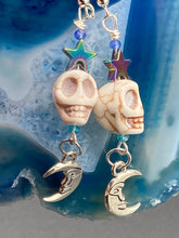 Load image into Gallery viewer, Galaxy Cosmos Stardust Howlite Skull Bead Earrings - star shaped rainbow hematite beads and smiling crescent moons. These pair of earrings have a lot of movement and shimmer for that witchy vibe. You can dress these up or down, it will definitely give your outfit a unique look.  Measurements: 2 ” in length
