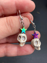 Load image into Gallery viewer, Howlite Skull Beads Earrings With Large Star Shapes Rainbow Hematite Bead. Versatile style, pastel goth, celestial stardust, witchy, day of the dead. You can dress these up or down, it will definitely give your outfit a unique look.   Measurements: 1 ” in length
