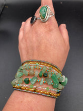 Load image into Gallery viewer, This Bohemian, Hippie Natural Genuine Stone Bracelet is composed of nine strands of shimmery multi-color glass beads and natural green aventurine chip stones. This striking, nature-inspired style showcases a vibrant blend of gold, silver, green, and turquoise beads, with a range of sizes, including both large and small round beads.   Measurements:  Bracelet: 8 1/4&quot; in length
