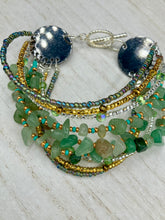 Load image into Gallery viewer, This Bohemian, Hippie Natural Genuine Stone Bracelet is composed of nine strands of shimmery multi-color glass beads and natural green aventurine chip stones. This striking, nature-inspired style showcases a vibrant blend of gold, silver, green, and turquoise beads, with a range of sizes, including both large and small round beads.   Measurements:  Bracelet: 8 1/4&quot; in length
