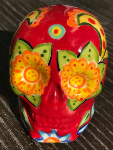 This ceramic skull statuette is a stunning piece of art inspired by nature. Its vibrant red hue is decorated with multi-color floral motifs, hearts, leaves and colorful accents, creating a beautiful piece of hand-painted, Day of the Dead-themed art. Measurements: H 2 3/4” x W 2” x D 2”