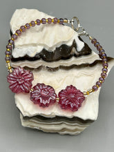 Load image into Gallery viewer, This light purple-pink pressed glass floral beaded bracelet offers delightful detailing with its iridescent shimmer finish. Constructed with metal wire and a lobster claw clasp for secure closure.  Measurements:  Bracelet: 8&quot; in length
