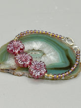 Load image into Gallery viewer, This light purple-pink pressed glass floral beaded bracelet offers delightful detailing with its iridescent shimmer finish. Constructed with metal wire and a lobster claw clasp for secure closure.  Measurements:  Bracelet: 8&quot; in length
