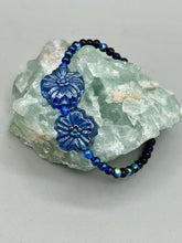 Load image into Gallery viewer, This Dark Blue Violet Pressed Glass Floral Beaded Bracelet features exquisitely detailed components with an iridescent shimmer finish. The piece is crafted with metal wire and a lobster claw clasp.  Measurements:  Bracelet: 8&quot; in length 
