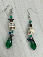 Load image into Gallery viewer, Mini Howlite Skull Bead Earrings large star shaped rainbow hematite bead with a large bright green teardrop shaped glass bead on the bottom of the skull for max shimmer and movement. Ultimate Chingona, Cabrona, Latina Chicana, Goth, Vampire Goth, Dark Witchy, La Bruja Style. You can dress these up or down, it will definitely give your outfit a unique look. You can dress these up or down, it will definitely give your outfit a unique look.  Measurements: 2 ” in length
