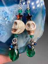 Load image into Gallery viewer, Mini Howlite Skull Bead Earrings large star shaped rainbow hematite bead with a large bright green teardrop shaped glass bead on the bottom of the skull for max shimmer and movement. Ultimate Chingona, Cabrona, Latina Chicana, Goth, Vampire Goth, Dark Witchy, La Bruja Style. You can dress these up or down, it will definitely give your outfit a unique look. You can dress these up or down, it will definitely give your outfit a unique look.  Measurements: 2 ” in length
