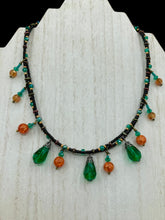 Load image into Gallery viewer, This necklace is the perfect addition to any collection, boasting a dark, elegant aesthetic inspired by nature. Comprised of two strands of glass beads with a variety of shapes and colors, it offers subtle autumnal vibrancy with its orange and green pumpkin-shaped glass beads. This piece is full of shimmer and complexity, providing unique depth and flair. Necklace is 16 1/2” in length, can be adjusted up to 18 1/2&quot;
