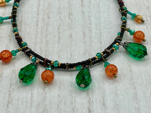Load image into Gallery viewer, This necklace is the perfect addition to any collection, boasting a dark, elegant aesthetic inspired by nature. Comprised of two strands of glass beads with a variety of shapes and colors, it offers subtle autumnal vibrancy with its orange and green pumpkin-shaped glass beads. This piece is full of shimmer and complexity, providing unique depth and flair. Necklace is 16 1/2” in length, can be adjusted up to 18 1/2&quot;
