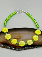Load image into Gallery viewer, This delicate jewelry displays an array of gentle hues, vibrant yet soft.This light yellow pressed glass floral beaded bracelet and earrings set features an iridescent shimmer finish and is crafted with metal wire and a lobster claw clasp for easy closure. Measurements:  Bracelet: 8 1/2&quot; in length   Earrings: 1 1/4&quot; length
