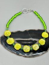 Load image into Gallery viewer, This delicate jewelry displays an array of gentle hues, vibrant yet soft.This light yellow pressed glass floral beaded bracelet and earrings set features an iridescent shimmer finish and is crafted with metal wire and a lobster claw clasp for easy closure. Measurements:  Bracelet: 8 1/2&quot; in length   Earrings: 1 1/4&quot; length
