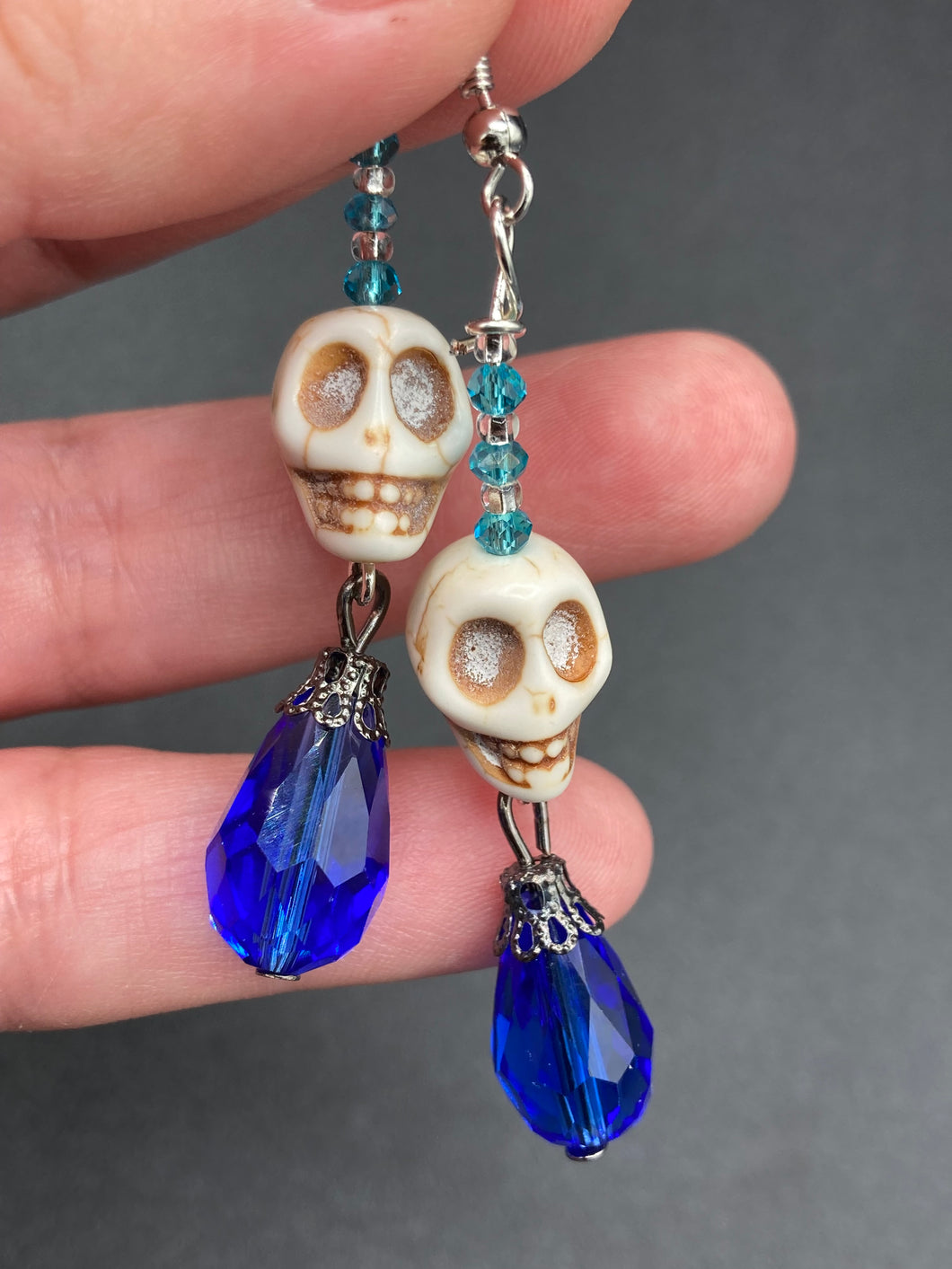 Mini Howlite Skull Bead Earrings and large bright blue teardrop shaped glass bead for major shimmery movement. Ultimate Chingona, Cabrona, Latina Chicana, Goth, Vampire Goth, Dark Witchy, La Bruja Style. You can dress these up or down, it will definitely give your outfit a unique look.   Measurements: 2 ” in length
