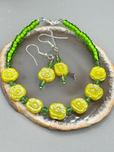 Load image into Gallery viewer, This delicate jewelry displays an array of gentle hues, vibrant yet soft.This light yellow pressed glass floral beaded bracelet and earrings set features an iridescent shimmer finish and is crafted with metal wire and a lobster claw clasp for easy closure. Measurements:  Bracelet: 8 1/2&quot; in length   Earrings: 1 1/4&quot; length
