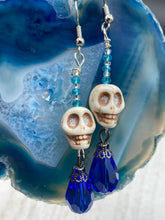 Load image into Gallery viewer, Mini Howlite Skull Bead Earrings and large bright blue teardrop shaped glass bead for major shimmery movement. Ultimate Chingona, Cabrona, Latina Chicana, Goth, Vampire Goth, Dark Witchy, La Bruja Style. You can dress these up or down, it will definitely give your outfit a unique look.   Measurements: 2 ” in length
