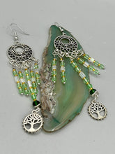 Load image into Gallery viewer, Be mesmerized by these large cascade style earrings, featuring five delicate strands of light green, iridescent and gold-tone beads with a tree of life charm for an eye-catching effect. Perfect for whimsical, nature-inspired looks, these earrings will liven up any outfit.  Measurements: 3 3/4” in length 
