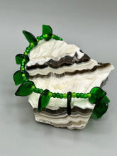 Load image into Gallery viewer, This nature-inspired jewelry is crafted from shimmering glass beads in shades of light and dark green as well as clear iridescent and gold tones. Light and dark green glass leaf beaded anklet and earrings provide intricate detailing. Crafted with metal wire and a barrel screw clasp, they offer a secure fit.
