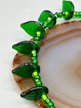 Load image into Gallery viewer, This nature-inspired jewelry is crafted from shimmering glass beads in shades of light and dark green as well as clear iridescent and gold tones. Light and dark green glass leaf beaded anklet and earrings provide intricate detailing. Crafted with metal wire and a barrel screw clasp, they offer a secure fit.
