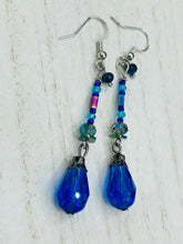 Load image into Gallery viewer, This beautifully and bold set of glass beaded earrings were inspired by the vibrant and beautiful colors of the galaxy and the cosmos full of colors that makes a stunning statement piece of jewelry. Rectangular rainbow Hematite beads add a different texture to the style. This is a bold piece of jewelry, a “must have”to your collection.   Measurements: 2” in length
