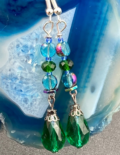 ﻿Beautiful and bold set of glass beaded earrings were inspired by the stunning and vibrant peacock feathers, full of color that makes a unique statement piece of jewelry.  The primary color is the bright green glass beads that contain hues of blues, purples, and a tint of gold to complement each other and I added a different size and shape beads to create texture to the style. This is a bold piece of jewelry, a “must have” to your collection.   Measurements: 2” in length