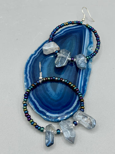 These ultra-trendy crystal nugget and glass beaded hoop earrings are perfect for any hippie or bohemian look. The dark blue glass beads give off an iridescent shimmer and blend brilliantly with the luster blue crystals, creating an eye catching contrast and a unique touch of nature-inspired beauty. Measurements: 2 1/4