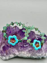 Load image into Gallery viewer, This pair of earrings features a turquoise magnesite floral bead with a vibrant orange glass bead and natural green aventurine stone chips juxtaposed against gold and blue glass beads. Measurements: 2" length 
