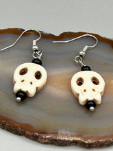 Load image into Gallery viewer, These stylish skull earrings are perfect for adding a unique flair to any outfit. Whether you&#39;re looking for a Dia De Los Muertos accessory or simply looking to draw inspiration, these goth pieces perfectly capture the vampire goth, witchy, dark, Chingona Cabrona, Latina Chicana styles.  Measurements: 1 1/4 ” in length

