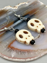 Load image into Gallery viewer, These stylish skull earrings are perfect for adding a unique flair to any outfit. Whether you&#39;re looking for a Dia De Los Muertos accessory or simply looking to draw inspiration, these goth pieces perfectly capture the vampire goth, witchy, dark, Chingona Cabrona, Latina Chicana styles.  Measurements: 1 1/4 ” in length
