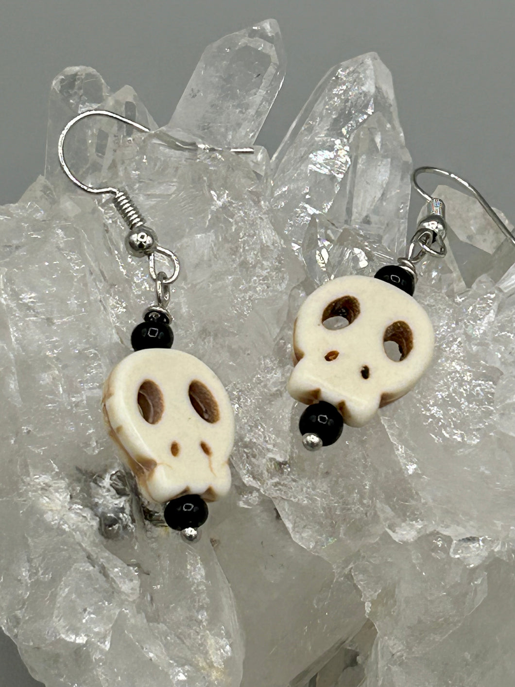 These stylish skull earrings are perfect for adding a unique flair to any outfit. Whether you're looking for a Dia De Los Muertos accessory or simply looking to draw inspiration, these goth pieces perfectly capture the vampire goth, witchy, dark, Chingona Cabrona, Latina Chicana styles.  Measurements: 1 1/4 ” in length