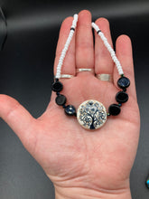 Load image into Gallery viewer, This impressive 24mm reconstituted quartzite lentil bead creates an eye-catching statement piece. The black and white glass beads add a sophisticated touch to its understated tree print. Perfectly suited to casual and formal occasions alike, this stunning necklace will complete any look. It was inspired by the stunning landscapes found in the U.S. National Arboretum in D.C.  Measurements:  Necklace is 17 &quot; in length
