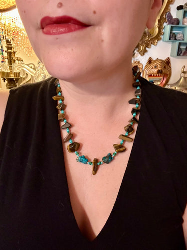 Bold earthy tone necklace contains large natural tigers eye stone chips with blue and green turquoise glass beads. Colorful and bold strand will make a perfect statement piece.    Measurements:    Necklace is 18 3/4 