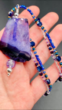 Load image into Gallery viewer, For The Love Of Nature - Vibrant Purple Agate Nature Stone With Two Strands of Multi-Color Glass Beaded Necklace. Large agate stone is full of purple hues from sheer, to vibrant violet, to deep dark purples. This beautiful agate necklace is the perfect summer necklace.   Measurements: Necklace is 15 1/2” adjustable up to 18" in length - pendant is 2 1/2” Height
