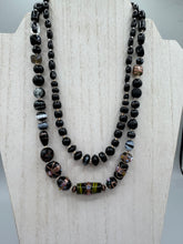 Load image into Gallery viewer, Add flair to your look with this unique large and chunky hand beaded necklace. Featuring a wide variety of mixed black glass beads in different sizes and shapes, this intricately-crafted statement piece offers a bold, hippie-chic, shabby-chic, and bohemian style.  Measurements:  Necklace is 18” in length, can be adjusted up to 20&quot;
