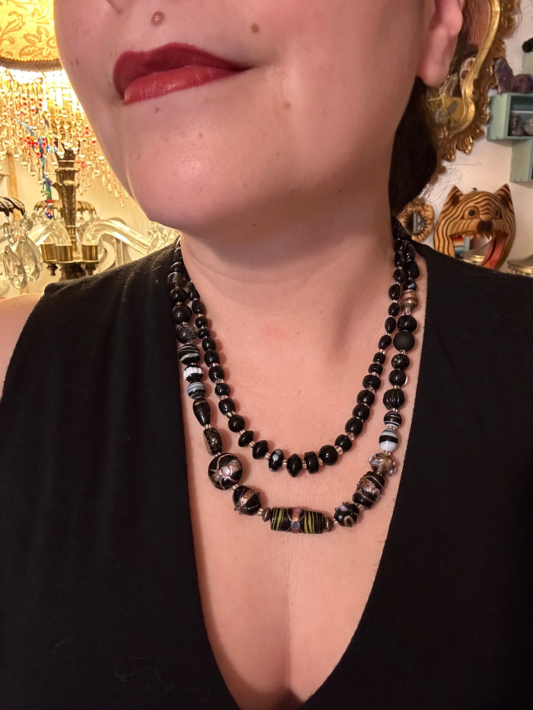 Add flair to your look with this unique large and chunky hand beaded necklace. Featuring a wide variety of mixed black glass beads in different sizes and shapes, this intricately-crafted statement piece offers a bold, hippie-chic, shabby-chic, and bohemian style.  Measurements:  Necklace is 18” in length, can be adjusted up to 20