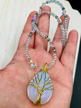 Load image into Gallery viewer, This opalite stone pendant with its shimmering hues of blue, gold, and pink is inspired by the whimsical beauty of nature. I created a beaded necklace using iridescent glass beads with the same colors of blue, gold, and pink to enhance the look of the Vibrant Tree Of Life Opalite Wired Stone Pendant. Measurements: Necklace is 20”
