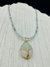 Load image into Gallery viewer, This opalite stone pendant with its shimmering hues of blue, gold, and pink is inspired by the whimsical beauty of nature. I created a beaded necklace using iridescent glass beads with the same colors of blue, gold, and pink to enhance the look of the Vibrant Tree Of Life Opalite Wired Stone Pendant. Measurements: Necklace is 20”
