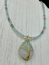 Load image into Gallery viewer, This opalite stone pendant with its shimmering hues of blue, gold, and pink is inspired by the whimsical beauty of nature. I created a beaded necklace using iridescent glass beads with the same colors of blue, gold, and pink to enhance the look of the Vibrant Tree Of Life Opalite Wired Stone Pendant. Measurements: Necklace is 20”
