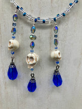 Load image into Gallery viewer, This adjustable collar-style necklace features two shimmery strands of silver and blue glass beads, with three skull charms boasting large, luminous blue teardrop glass beads adding extra shimmer and movement.  Measurements:  Necklace is 14 3/8” adjustable up to 18" in length
