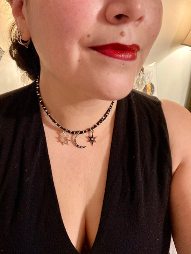 Whimsical Celestial Crescent Moon And Stars Collar Stye Adjustable Glass Beaded Necklace. Two strands are held together with double-hole black and silver beads to keep a collar shape. This necklace beautifully drapes across your neck, a fierce, bold and elegant piece of jewelry. Perfect for Goth, Witchy, and Stardust Celestial Styles.  Measurements:    Necklace is 15” in length (“collar” style), can be adjusted up to 18