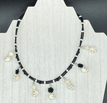 Load image into Gallery viewer, This sophisticated, yet dark-themed necklace utilizes small howlite skull beads along with black and white quartize floral beads to capture the iconic floral crown of Frida Kahlo. This Chingona, Cabrona, Latina Chicana, Goth, Vampire Goth, Dark Witchy Style jewelry can be used to inspire and to celebrate Dia de los Muertos. Equally suitable for dressy and casual outfits, the piece gives a unique edge to any look.
