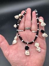 Load image into Gallery viewer, This sophisticated, yet dark-themed necklace utilizes small howlite skull beads along with black and white quartize floral beads to capture the iconic floral crown of Frida Kahlo. This Chingona, Cabrona, Latina Chicana, Goth, Vampire Goth, Dark Witchy Style jewelry can be used to inspire and to celebrate Dia de los Muertos. Equally suitable for dressy and casual outfits, the piece gives a unique edge to any look.

