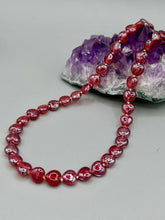 Load image into Gallery viewer, This ruby red heart-shaped glass beaded necklace features a shimmery and vivid iridescent hue, secured with a hook-eye clasp. Measurements:    Necklace is 19&quot; in length
