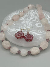 Load image into Gallery viewer, Add a touch of bohemian style to your look with these unique light purple pink flower glass earrings. Featuring detailed pressed glass beads and an iridescent shimmer finish, these earrings are perfect for a hippie vibe, shabby chic, or boho chic look. Nature-inspired and chic, these are the perfect earrings for any occasion. Measurements: 1 1/4&quot; length
