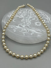 Load image into Gallery viewer, This single strand necklace features gold tone faux pearl beads for a classic, elegant aesthetic. Measurements:   Necklace is 18&quot; in length
