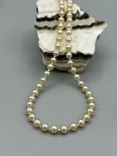 Load image into Gallery viewer, This single strand necklace features gold tone faux pearl beads for a classic, elegant aesthetic. Measurements:   Necklace is 18&quot; in length
