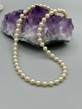 Load image into Gallery viewer, This single strand necklace features gold tone faux pearl beads for a classic, elegant aesthetic. Measurements:   Necklace is 18&quot; in length
