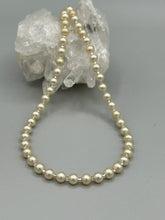 Load image into Gallery viewer, This single strand necklace features gold tone faux pearl beads for a classic, elegant aesthetic. Measurements:   Necklace is 18&quot; in length
