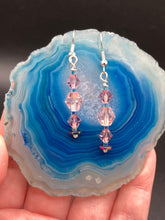 Load image into Gallery viewer, These dainty glass beaded earrings in soft pink and purple, featuring rainbow hematite beads, are perfect for summer ensembles and boho chic looks. An ideal accessory for nature lovers, these earrings will enhance any style.  Measurements: 1 1/2” in length
