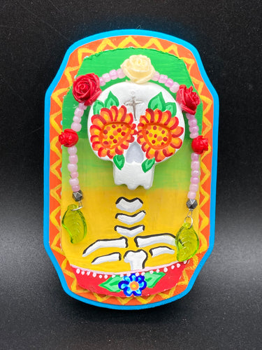  Transform your walls with this handcrafted polymer clay wall art. Showcasing a vibrant Frida Kahlo inspired calavera with hand-beaded floral crown, this Day of the Dead wall decor piece is perfect for adding a traditional Mexican folk art touch to any home.