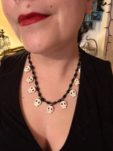Load image into Gallery viewer, This black and white Goth-style necklace displays a series of shimmering dark-toned glass beads that gracefully encircle the neck and feature hanging skull-shaped beads. A powerful, bewitching and audacious piece of jewelry.  Measurements: 19 1/4&quot;
